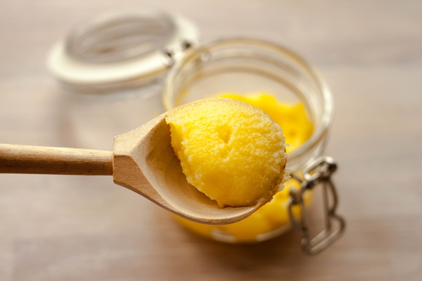ghee clarified butter yellow in glass jar with wooden spoon - Ленивые вареники