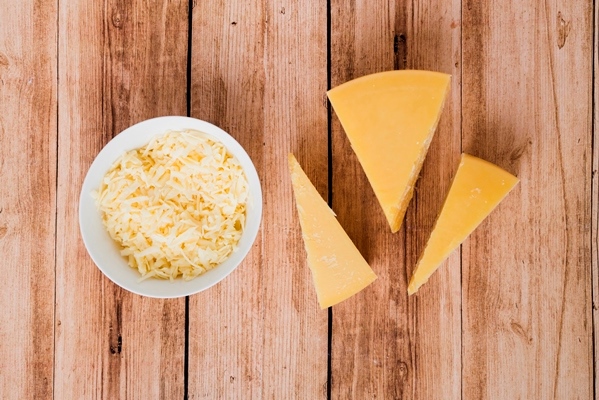 grated and triangular chunk cheese on wooden table - Бульон с гренками