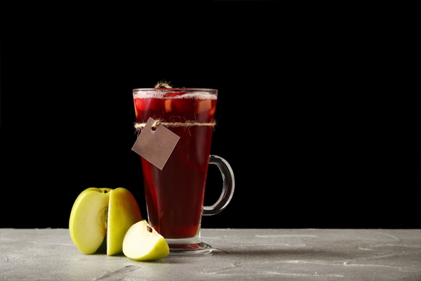 hot tea with apple in a mulled wine glass - Виноградный безалкогольный глинтвейн