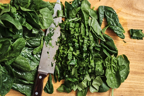 juicy spinach leaves chopped on a wooden cutting board the chef s knife lies on the table top view organic and healthy food the idea of making breakfast 1 - Омлет со шпинатом
