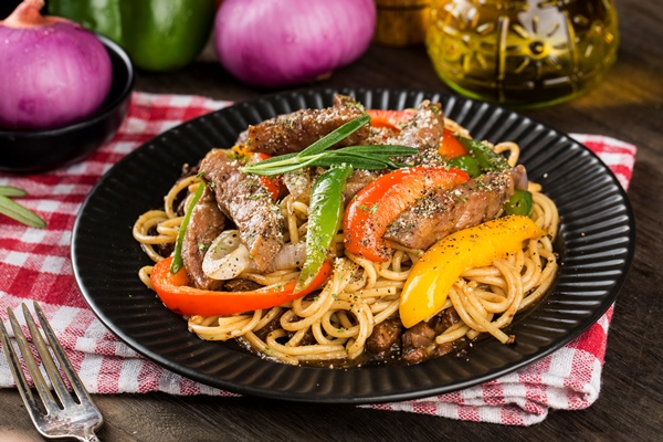 a plate of delicious pasta with beef and green pepper - Тушёное мясо с макаронами