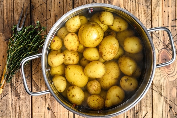 boiled baby potatoes in a saucepan - Мясной салат