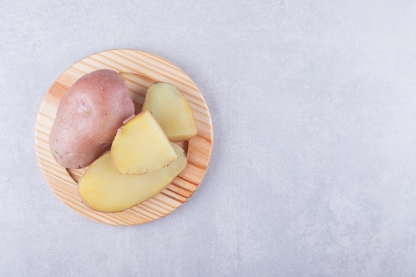 boiled delicious potatoes on wooden plate - Картофельный салат с огурцами и яйцом