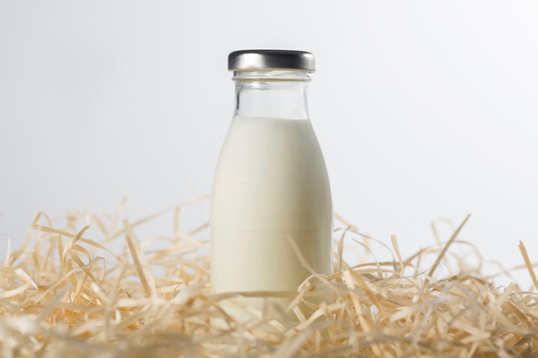 bottle of fresh milk in the hay on a white background healthy food - Ризотто