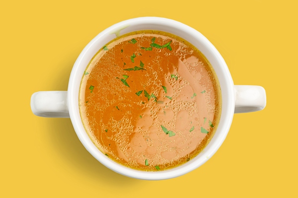 bowl of fresh chicken broth isolated on yellow background top view - Баранина тушёная с овощами