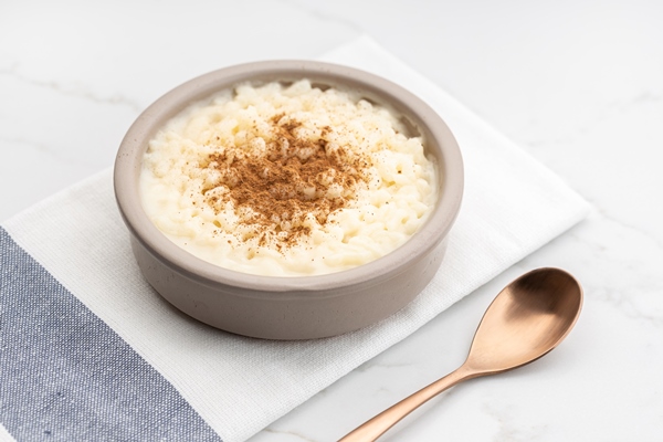 creamy rice pudding with cinnamon in bowl on white marble table typical spanish dessert - Гурьевская каша