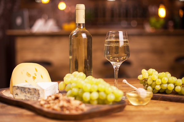 food festival with different cheeses and white wine in a vintage restaurant bottle of white wine fresh grapes - Правила подачи сыров