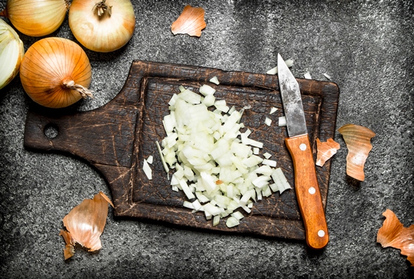 fresh chopped onion on the old board on rustic table - Сырный суп с копчёностями и молоком