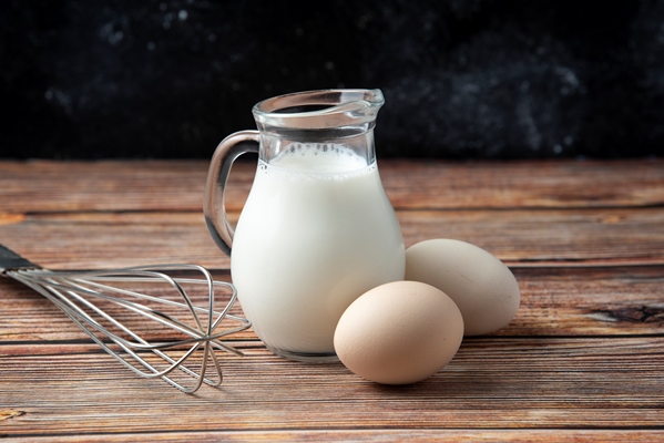 glass jug of milk eggs and whisker on wooden table - Суп-пюре из креветок