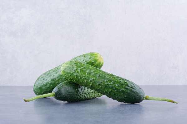 green cucumbers isolated on blue surface - Салат из картофеля и трески с хреном