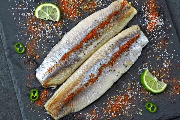 herring fillet with sea salt and spices on a stone black board norwegian herring fillets - Салат из сельди