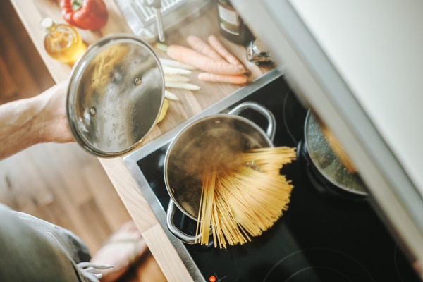 man cooking pasta in the kitchen - Спагетти с сыром