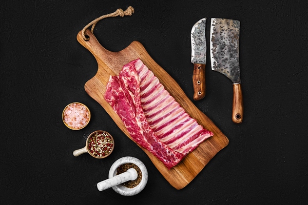 overhead view of raw lamb breast and flap on wooden cutting board - Рагу из баранины