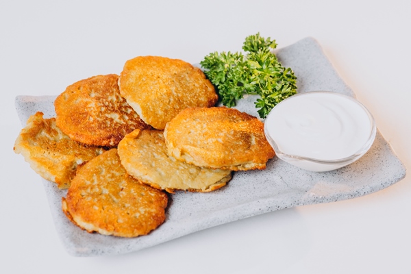 patato pancakes with sour cream isolated on wahite surface - Творожники с морковью