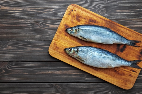 pickled atlantic herring fishes on a cutting board - Сельдь под шубой