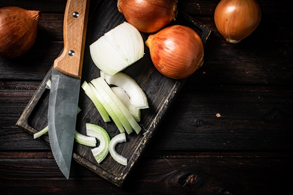 pieces of onion on a cutting board with a knife 1 - Мясной гуляш