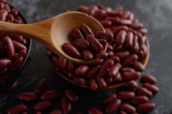 red beans in a wooden bowl and wooden spoon on the black cement floor - Баранина с фасолью