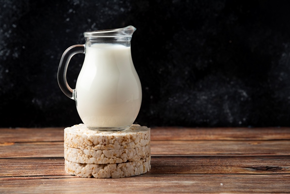 rice crackers and glass jug of milk on wooden table - Карамельный соус