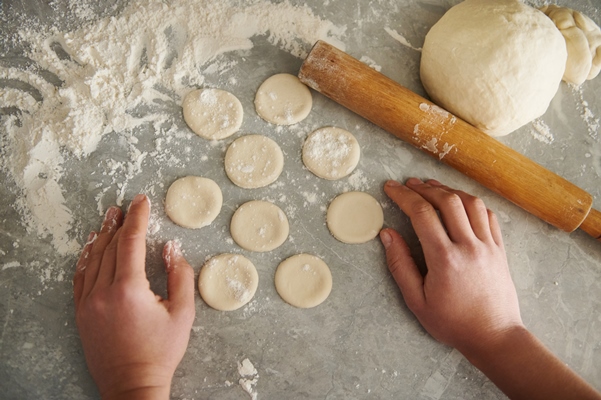 round shapes dough and rolling pin 3 4 n the floured table in the kitchen focus on hands - Суп из вишен с варениками