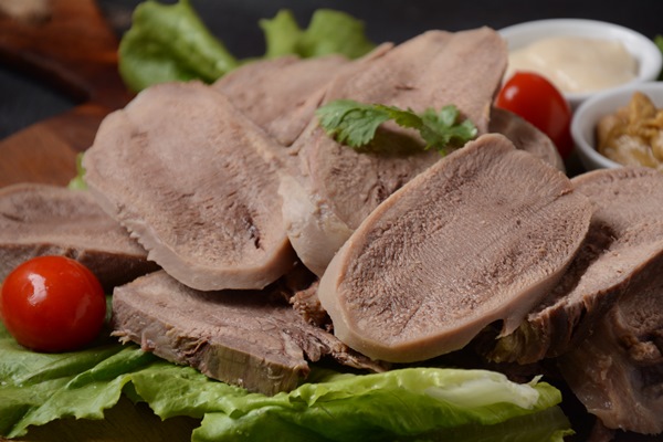 sliced beef tongue slices on a platter with lettuce leaves cherry tomatoes and dijon mustard on a wooden background 2 - Язык отварной под соусом