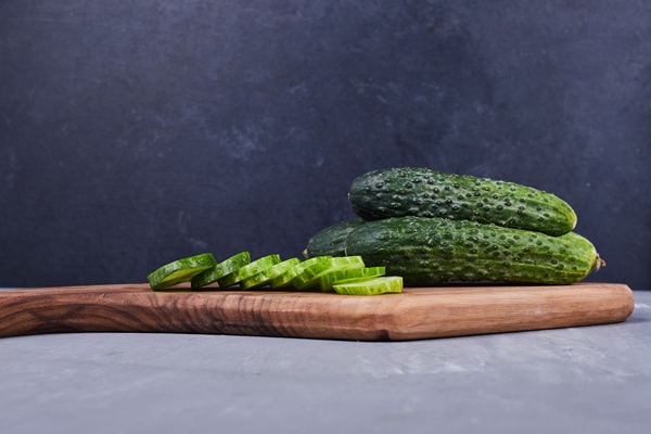 sliced cucumber or pickles on a wooden board - Салат с огурцом, морковью и яблоком