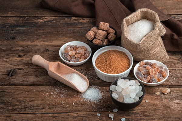 sugar of different types on a wooden background side view with copy space - Сладкая творожная масса