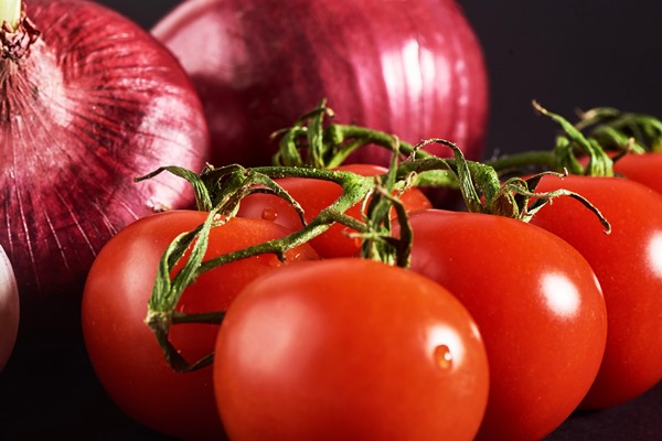 tomatoes onions and garlic are isolated on a black - Баранина с фасолью
