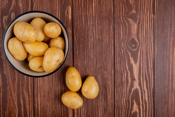 top view of new potatoes in bowl on wooden surface with copy space - Салат из картофеля и трески с хреном