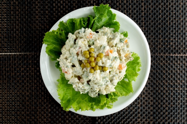 top view of olivier salad bowl garnished with lettuce - Салат "Оливье"