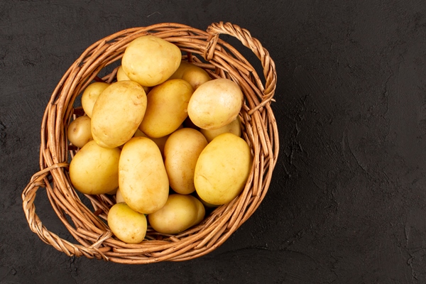 top view potatoes in basket on the dark floor - Салат из рыбы с помидорами