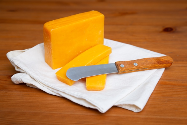 yellow cheese and knife laying on white cloth - Сырный суп с копчёностями и молоком