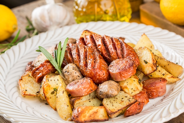 a plate of delicious potatoes and baked sausage - Колбаса жареная