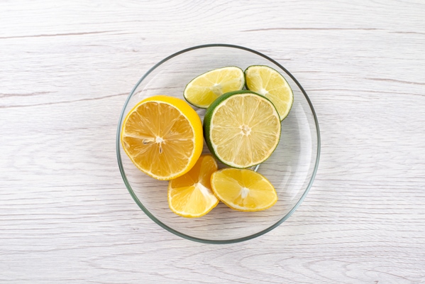 a top view sliced sour lemon juicy inside glass bowl on white desk fruit juice color - "Борщ" без варки