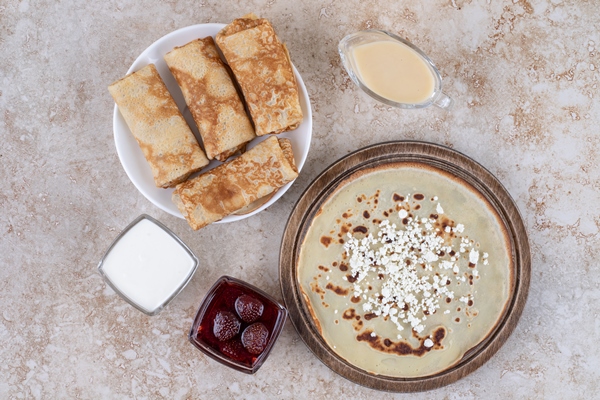 a white plate of tasty crepes and strawberry jam - Блинцы на йогурте