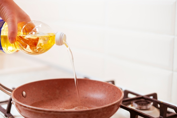 a woman hand pour cooking oil on the pan at home 2 1 - Монастырская кухня: рисовая каша с морковью, печенье макруд