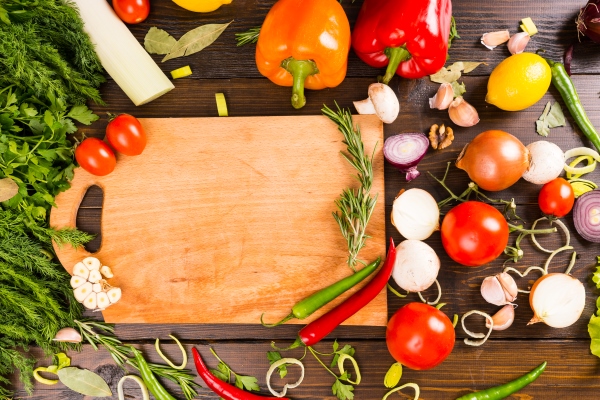 blank cutting board surrounded by peppers herbs tomatoes mushrooms and other savory flavored vegetables - Вешенки с овощами в маринаде
