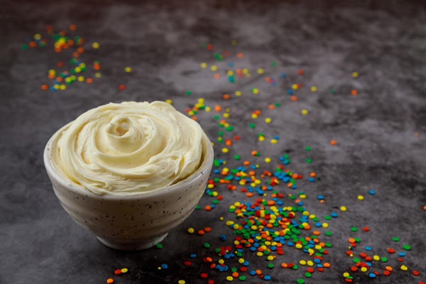 butter cream and sprinkles in bowl on dark background - Монастырская кухня: архиерейская солянка, постный "Наполеон"