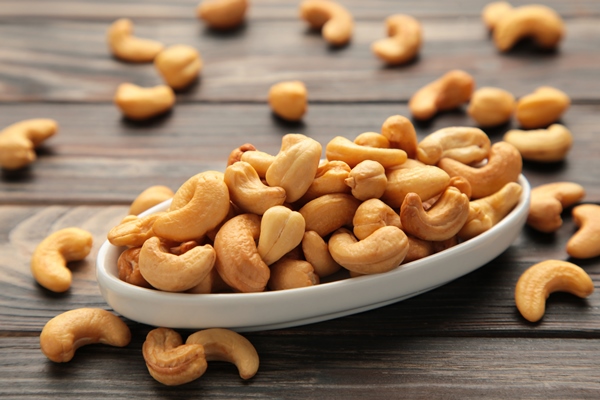 cashew nuts on white plate on brown wooden background top view - Постный соус "Тысяча островов"