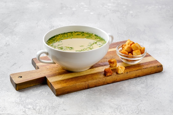 chicken stock with croutons on wooden serving board - Запеканка с мясом