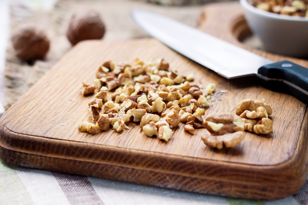 chopped walnuts on wooden cutting board - Монастырская кухня: жареная зубатка, запечённое яблоко с орехами