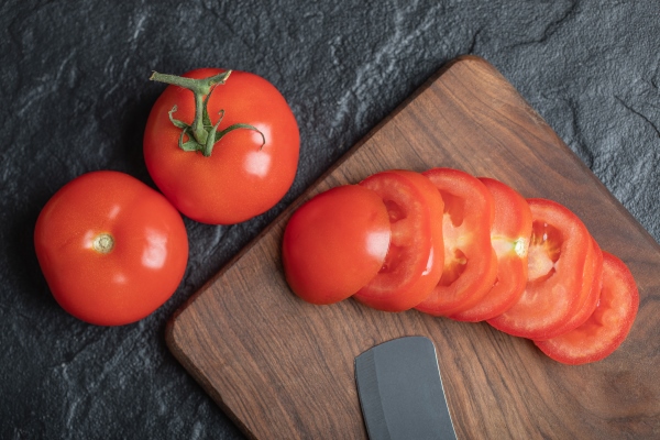 close up view of freshly picked juicy tomatoes on dark stone background high quality photo - Острая закуска из шампиньонов