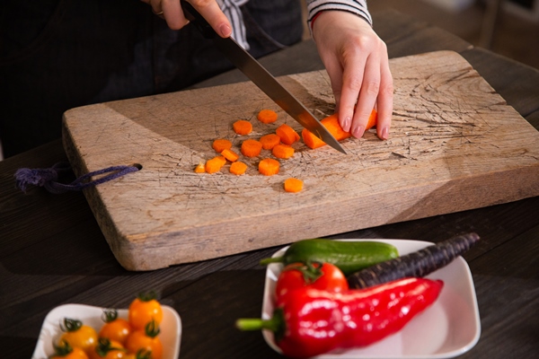 closeup of slicing carrot to cook a vegetarian meal - Монастырская кухня: рис с баклажанами, ревани