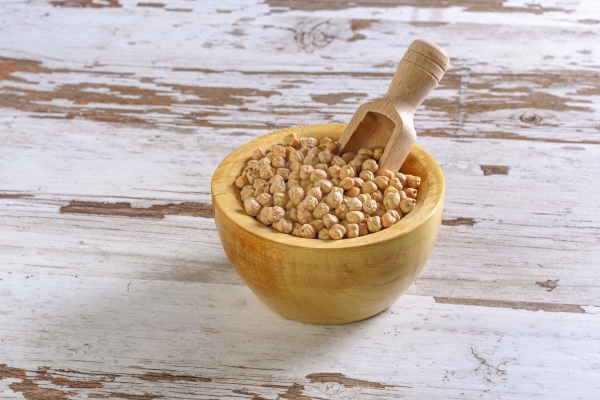 closeup shot of a rustic wooden bowl of raw chickpea cicer arietinum - Хумус с авокадо