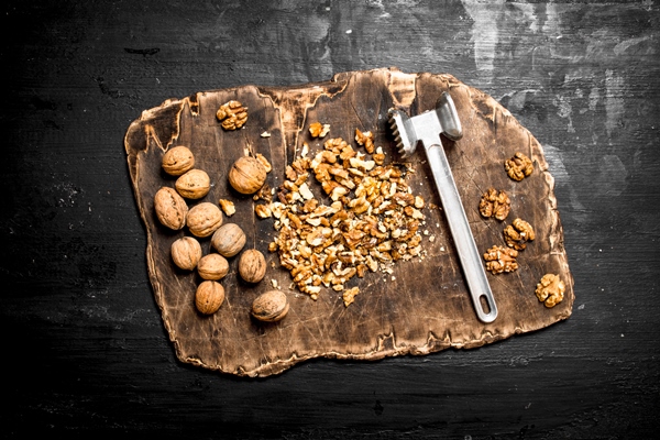 crushed walnuts with a hammer on old board on black chalkboard - Монастырская кухня: картофельные котлеты, маково-ореховые вафли