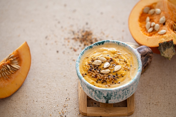 delicious composition with pumpkin soup in a beautiful ceramic dish seasonal food - Овсянка с хурмой и тыквой без варки