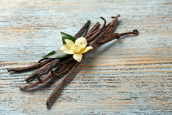 dried vanilla pods and flower on wooden background - Овсянка с манго, бананом и чиа
