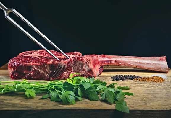 dry aged wagyu tomahawk steak wooden cutting board with spices parsley - Антрекот с картофелем