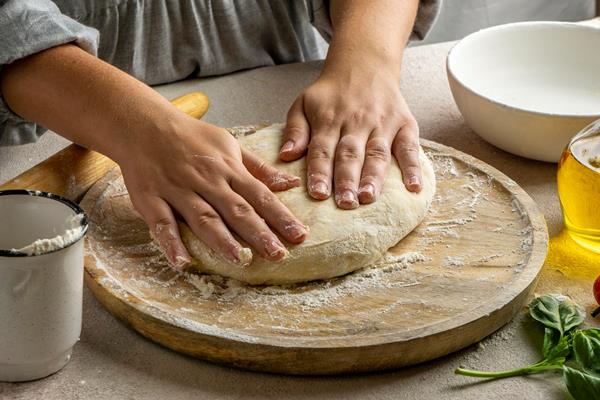 female cook preparing pizza dough - Беляши