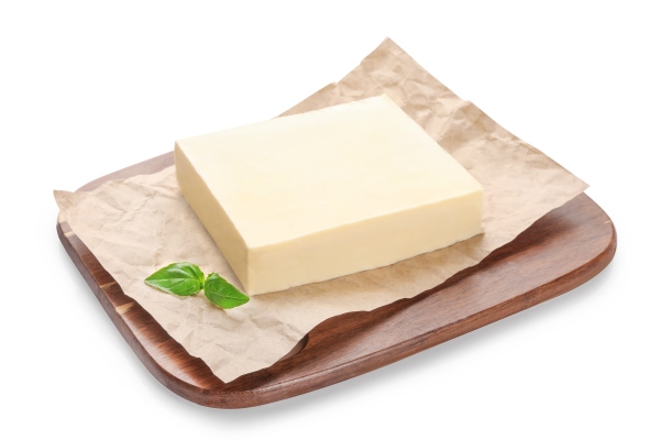 fresh butter block on wooden cutting board isolated on white - Пресное бездрожжевое тесто