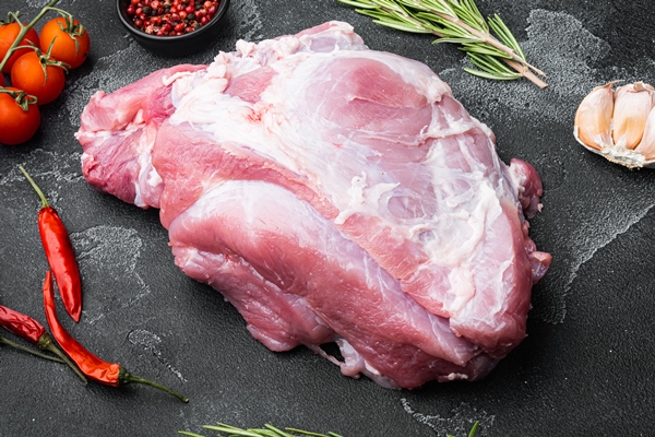 fresh pork with ingredients for cooking set on black dark stone table background - Жареная свинина